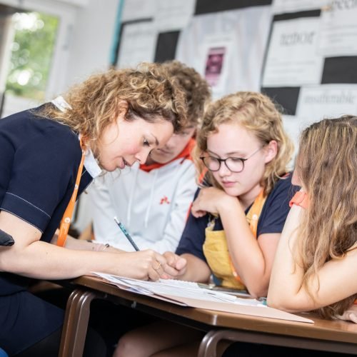 A tutor is teaching children in a summer school