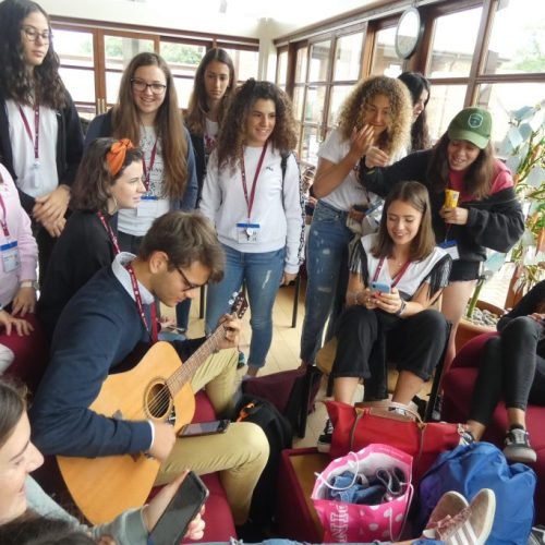 Chaucer College students and teacher are playing a guitar.