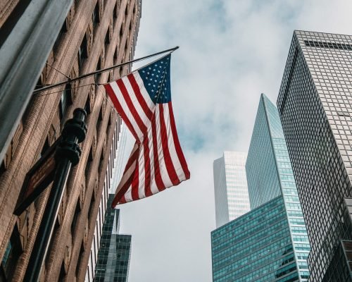 USA flag waving in New York City, symbolizing iconic city in the USA. Explore education with GTEC and embrace the American experience.